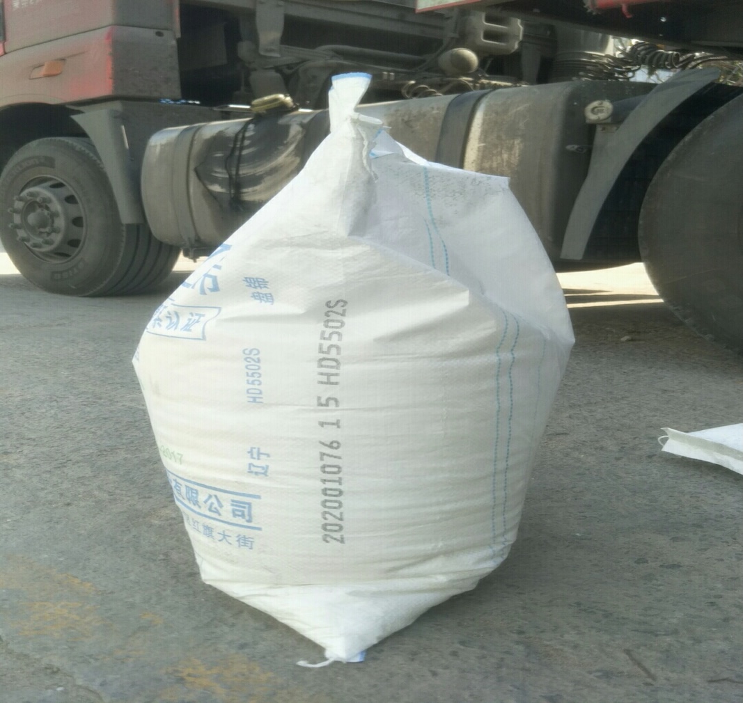 4eb83d1e-effc-4934-8928-74865aa15011_Huajin HDPE 5502S sveķu maisa sānu skats, uz kura ir apdrukāts HD5502S klases marķējums un ražošanas partijas kods blakus kravas automašīnai.jpg